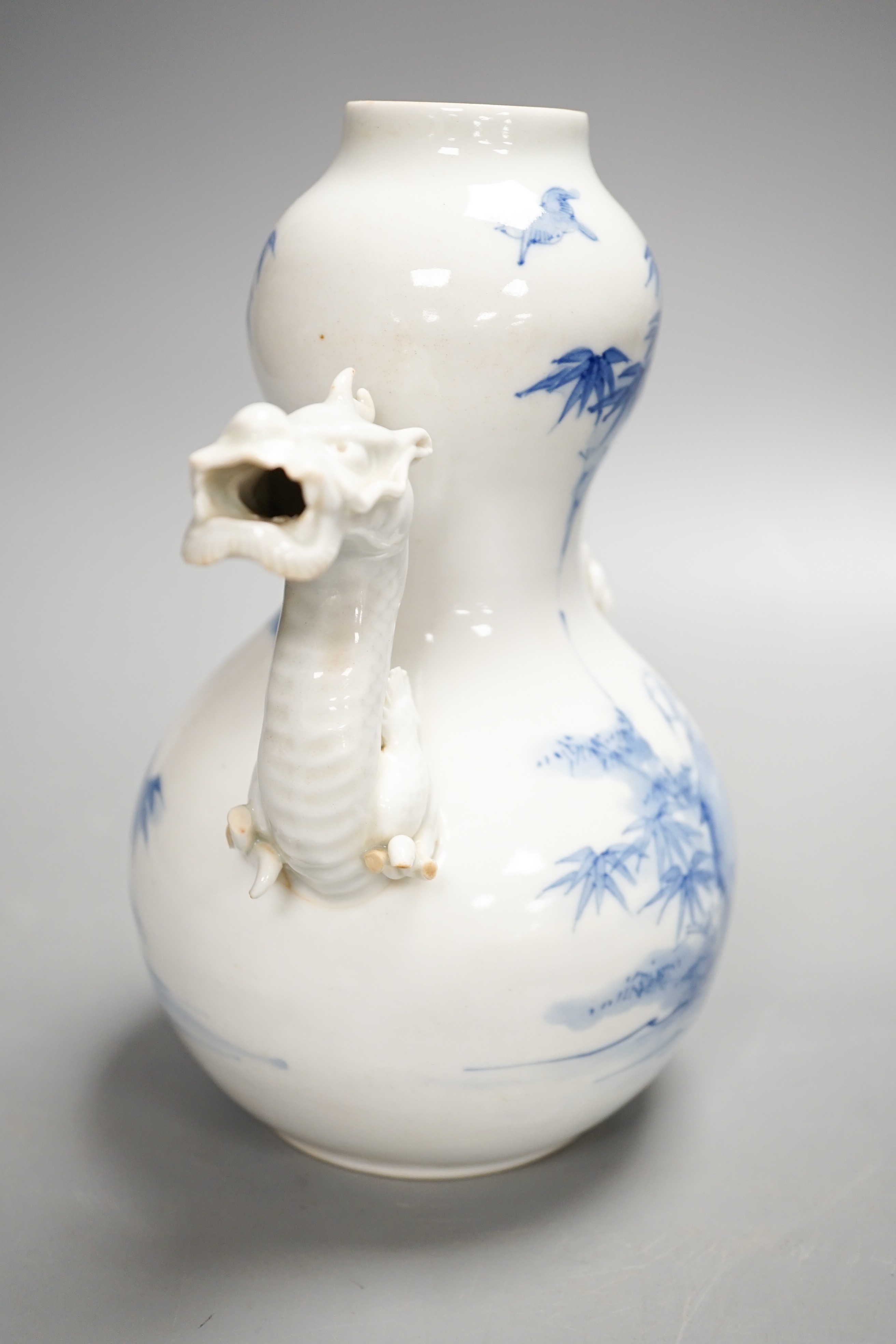 A Japanese Hirado blue and white 'dragon' wine pot, late 19th century, of double gourd shape, (losses) 19.5cm
